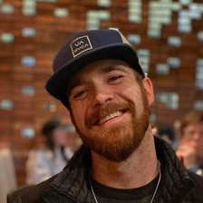 Corey Putney, founder of Corner Post Web, smiling in a navy cap and black jacket